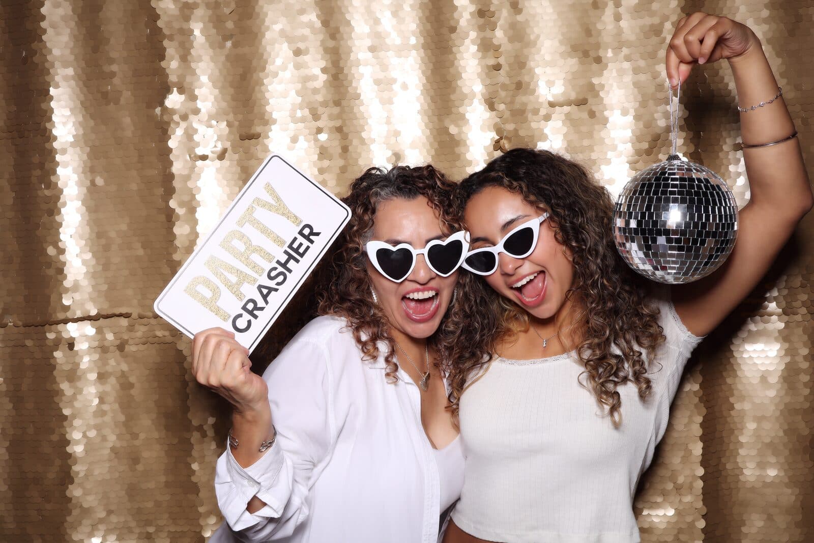 Two guests with heart sunglasses and a disco ball at the Shutter Bar photo booth